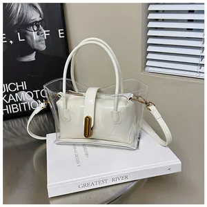 Detail of transparent PVC tote bag with cream leather inner pouch and gold metal buckle