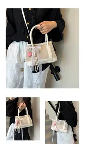 Detail of canvas handbag with white leather trim and decorative lace ribbon bow