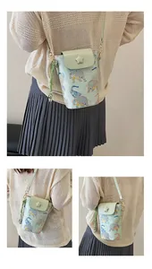 Detail of light green mini crossbody phone bag with ethnic elephant print and star charm