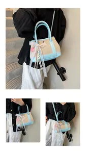 Detail of contrast stitching handbag with straw texture, lace trim, and charms