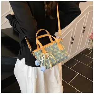 Dettaglio borsa a secchiello in denim con ciondolo tulipano e perle su pelle