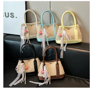 Detalle de mini bolsos de lona en cinco colores con colgantes de corazón y encaje