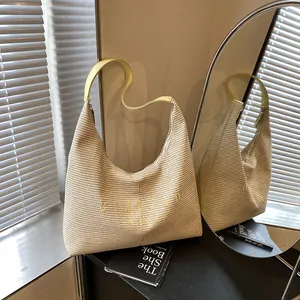 Elegante borsa a secchiello in paglia con tracolla in pelle e dettaglio di lettere gialle