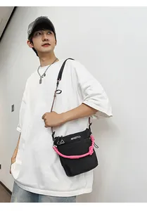 Dettaglio della borsa in nylon con corda rosa decorativa e stampa testuale bianca