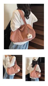 Close-up of pink water-resistant nylon tote bag with a white plush monster keychain