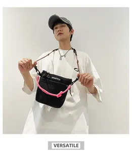 Borsa a tracolla in nylon con corde rosa e logo indossata su una maglietta bianca