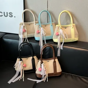 Cinco bolsos de lona en contraste con colgantes de corazón y cintas de encaje