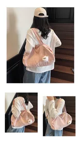 Detail of pink nylon tote bag with plush sheep charm shown from back and side view