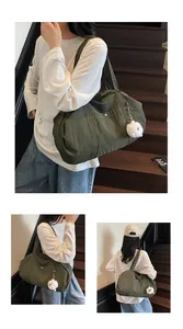 Close-up of olive green nylon tote bag featuring front metal snap pocket and plush charm