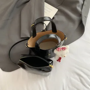 Elegante borsa a secchiello nera con ciondolo orsetto e tracolla per donna