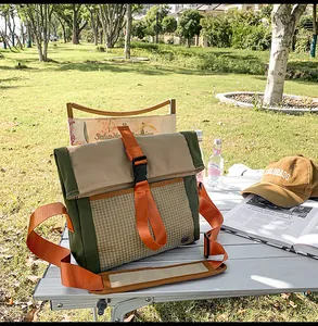 Detail of outdoor crossbody bag featuring green khaki patchwork and orange strap