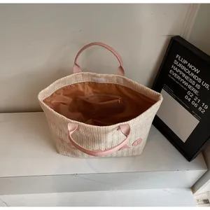 Détails de l'intérieur du sac cabas tissé avec poignées roses et poches de rangement