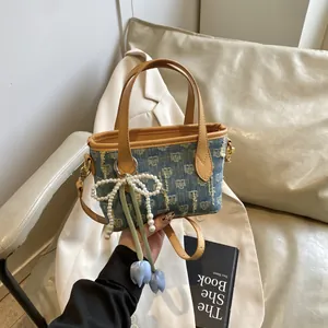 Mini borsa a secchiello in denim con motivo jacquard, finiture in pelle e ciondolo perla