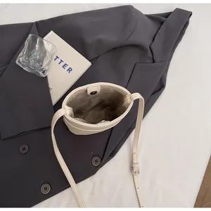 Dettaglio borsa a tracolla bianco crema con trama a grana e chiusura magnetica interna