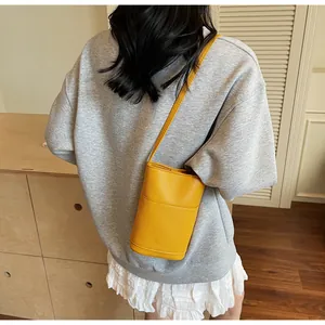 Dettaglio della trama in pelle martellata gialla su questa borsa a secchiello alla moda