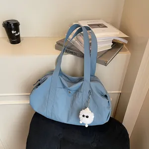 Waterproof nylon tote bag in blue with monster charm, perfect for daily commute and travel