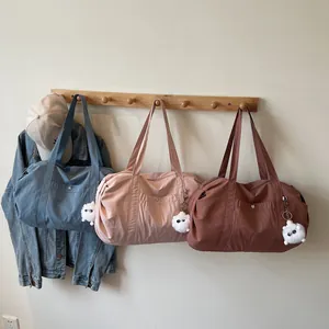 Waterproof large nylon tote bags in blue, pink, and red with plush monster pendants