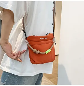 Dettaglio della borsa a tracolla in nylon arancione vivace con corda e etichetta Disney