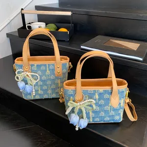 Borsa retrò in denim con finiture in pelle e ciondoli floreali per lo stile estivo chic