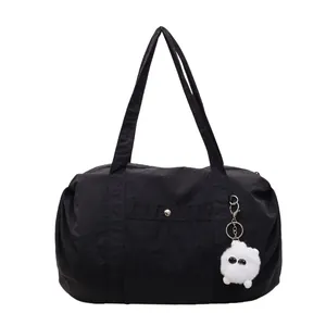 Lightweight black waterproof nylon tote bag with plush monster charm for commuting