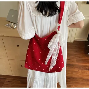Dettaglio della borsa tote rossa a fiori con un grande fiocco di pizzo bianco decorativo