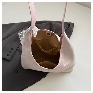 Detail view of pink tote bag interior featuring floral embroidery and magnetic snap