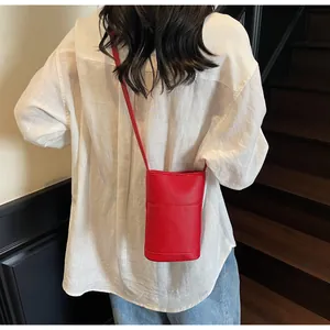 Dettaglio della trama litchi rossa su piccola borsa a tracolla quadrata chic