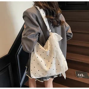 Dettaglio della borsa shopper floreale con pizzo bianco e delicati motivi a fiori neri