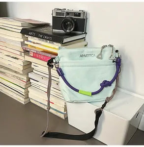 Dettaglio della borsa in nylon verde menta con corde viola e dettagli in metallo argento