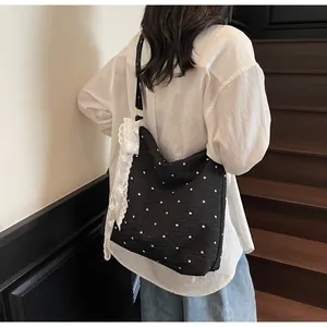Vista dettagliata della borsa tote nera floreale con pizzo bianco indossata da una modella