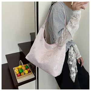 Detail of hobo shoulder bag featuring delicate butterfly embroidery and spacious leather design
