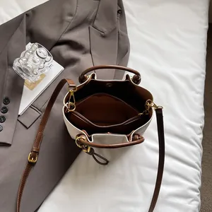 Borsa a secchiello minimalista in tela beige con finiture in pelle marrone e zip