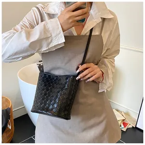 Dettaglio della borsa a secchiello in pelle intrecciata nera con motivo Intrecciato