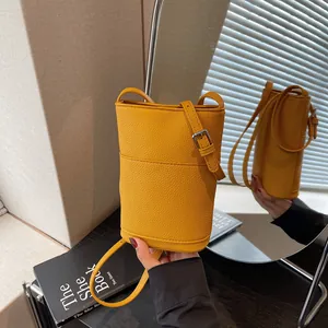 Elegante borsa a secchiello in pelle gialla con motivo litchi e tracolla regolabile