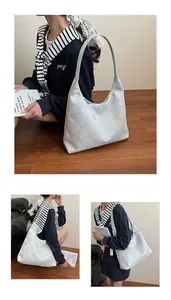 Detail view of light blue underarm tote bag with golden butterfly and floral prints
