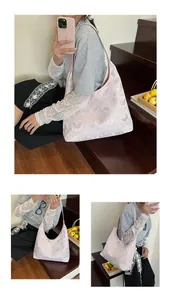 Close-up of light pink hobo bag featuring elegant butterfly and floral patterns
