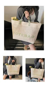 Gros plan d'un sac cabas tissé beige avec anses en cuir vert et inscription TOTEBAG