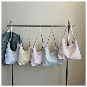 Detail showing colorful butterfly and floral hobo bags hanging on a rack