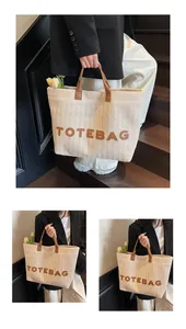 Détail du sac cabas en paille tissée avec anses en cuir marron et lettrage TOTEBAG