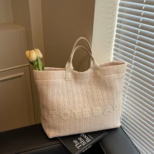 Sac fourre-tout minimaliste en paille tissée beige avec lettrage TOTEBAG pour la plage