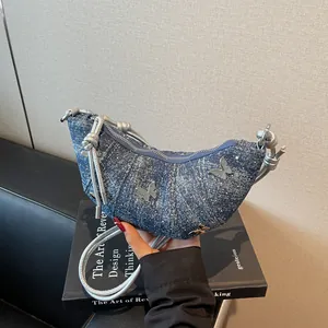 Borsa a mezzaluna in denim con farfalle d'argento e texture in tessuto lavato