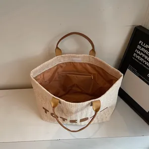 Sac cabas minimaliste en paille avec poignées en cuir marron et texte TOTEBAG pour l'été