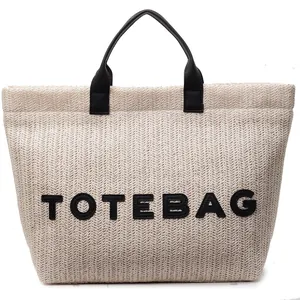 Sac cabas minimaliste en paille pour l'été avec anses en cuir et texte TOTEBAG brodé