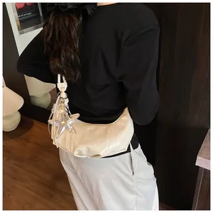 Chic off-white crescent bag with wrinkled patent leather and a silver star charm pendant