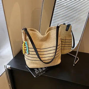 Borsa tote in paglia con strisce nere e ciondolo di perline per vacanze estive