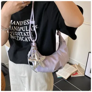 Detail of light purple crescent bag with silver star pendant and decorative knot strap
