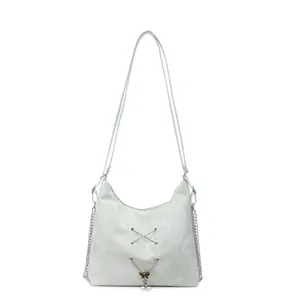 Mint green tote bag with metal X-decor and pearl butterfly charm on white background