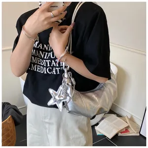 Close-up of silver pleated hobo bag featuring a shiny star pendant and metallic texture