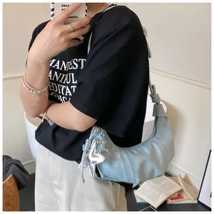 Detail of light blue pleated croissant bag with silver star and balloon dog pendants
