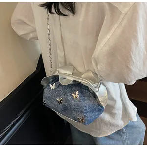 Detailed back view of a blue denim and silver bucket bag with metal butterfly charms